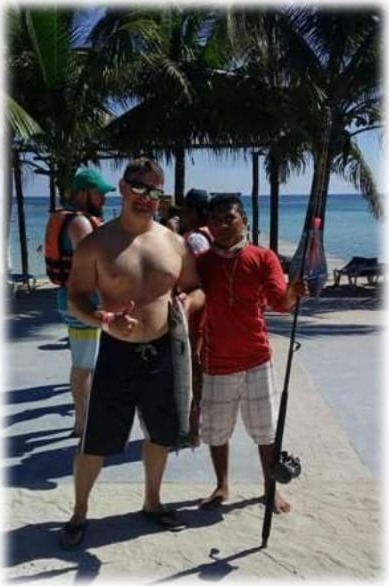 Locales y visitantes en la playa de Mahahual junto a las palmeras