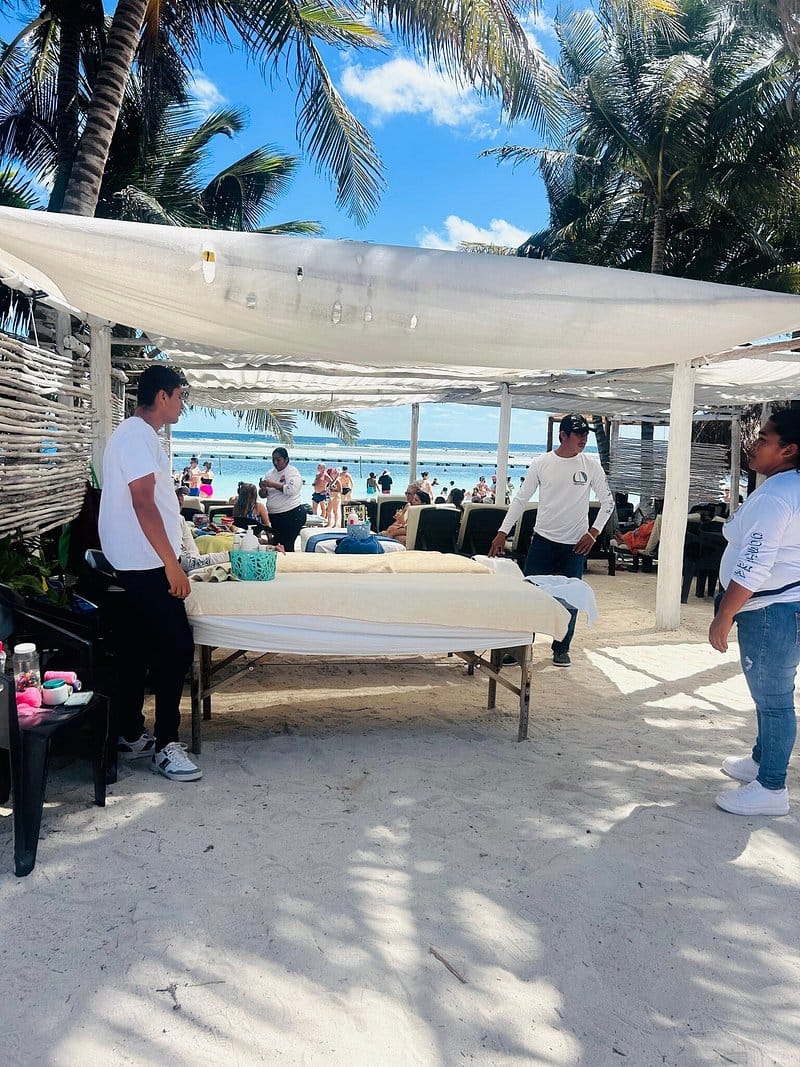 Camilla de masaje bajo una palapa frente al mar en Mahahual